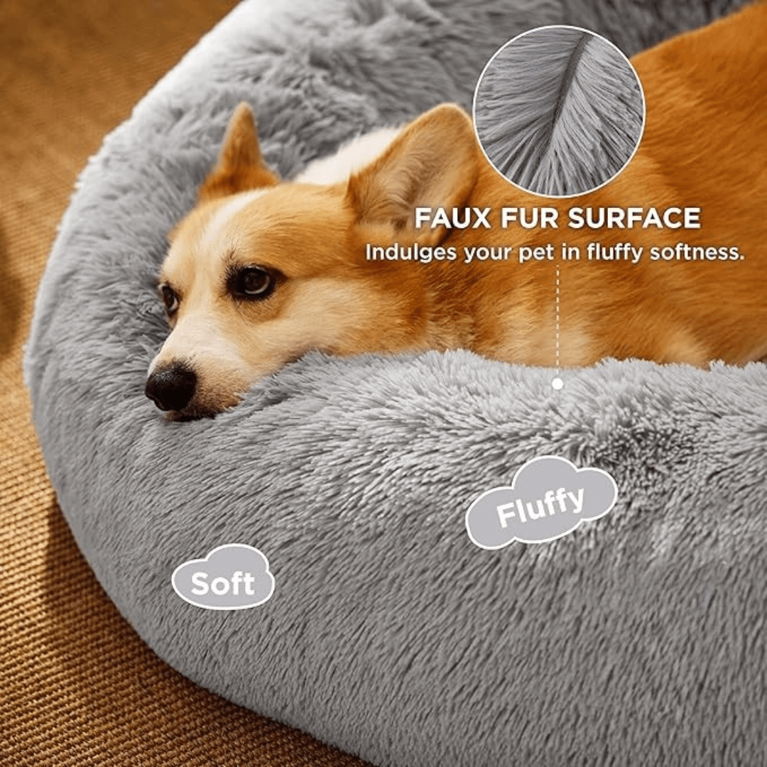Soft Donut Cuddler Pet Bed - Ultimate Anti-AnxietyDog lying on a gray faux fur pet bed with text highlighting features.Joypup